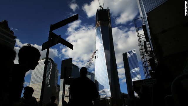Pedestrians walk by One World Trade Center on the eve of the 11th anniversary of the September 11 terrorist attacks on Monday, September 10 in New York City. Work proceeds at the former site of the World Trade Center Twin Towers.